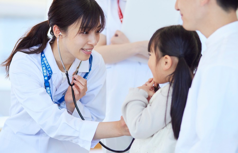 クリニックで子どもを診察する女性医師